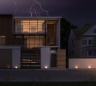 lightening storm above modern house with lights on