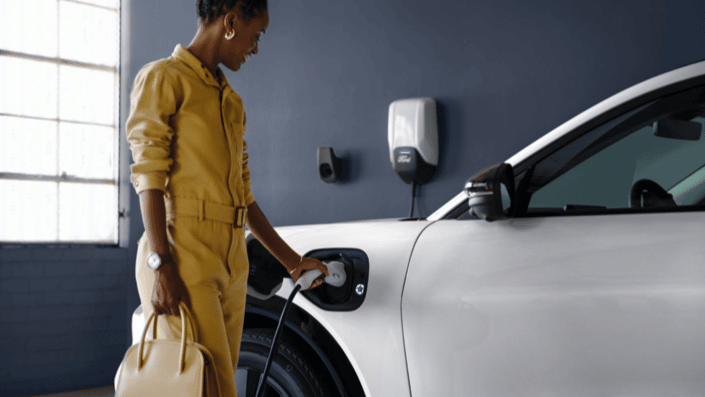 woman holding purse and charging white ev