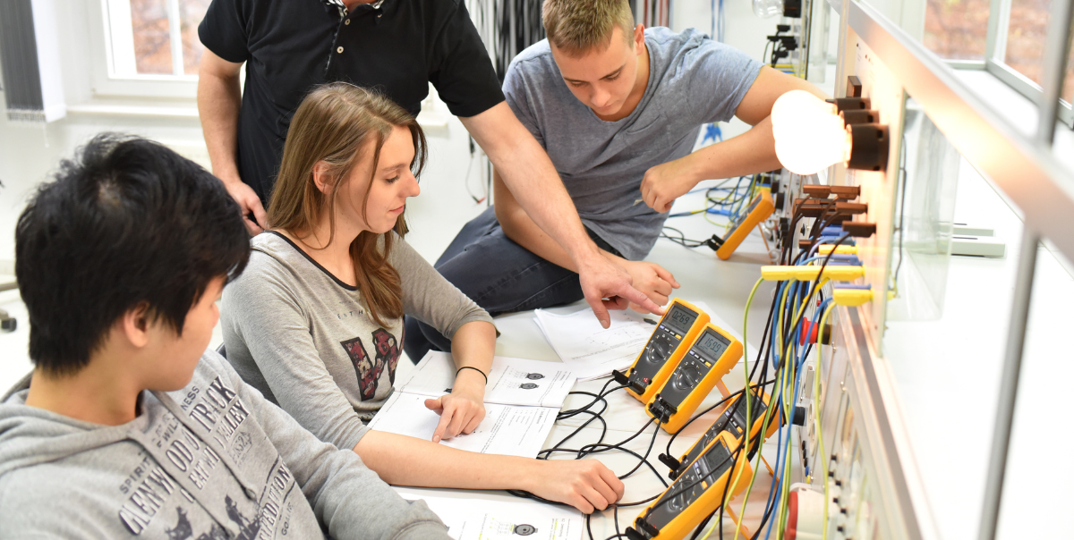 the future for evs is bright if enough electricians can be found. image of electrical apprentices being trained by a licensed electrician in a classroom setting as electrification needs more electrical contractors