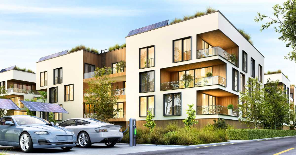 electrification is key to the multifamily home of the future. thumbnail image depicts a futuristic multifamily community with solar panels and ev charging stations.
