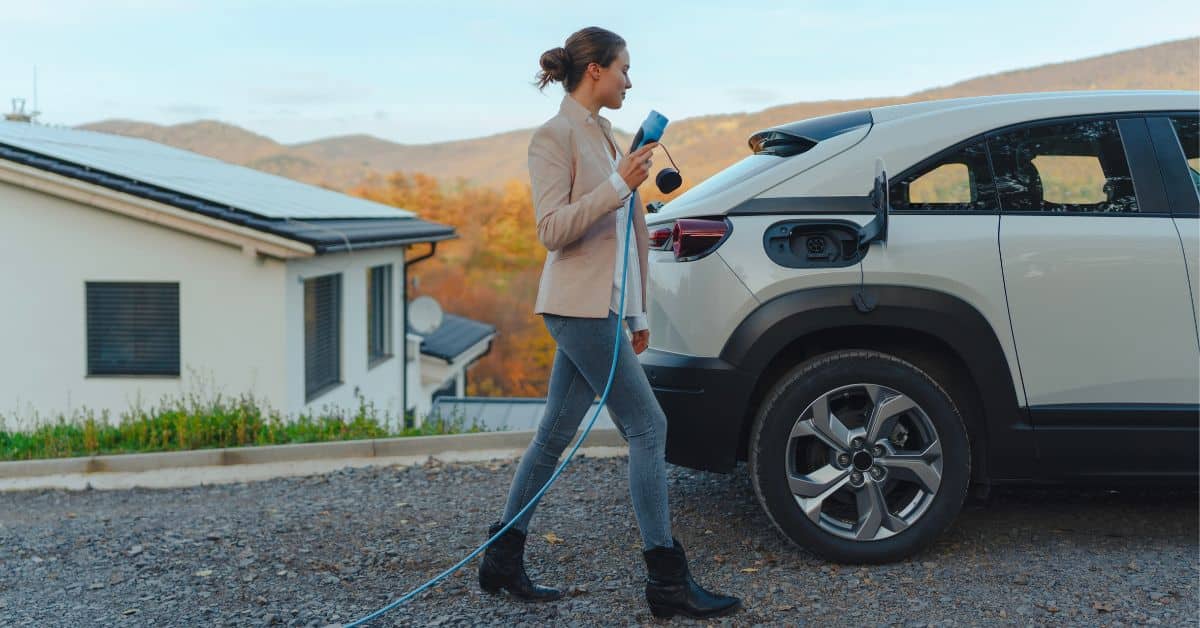 A woman plugging in her EV, illustrating the pivotal role of utilities in developing and implementing microgrid technology to support evolving energy needs