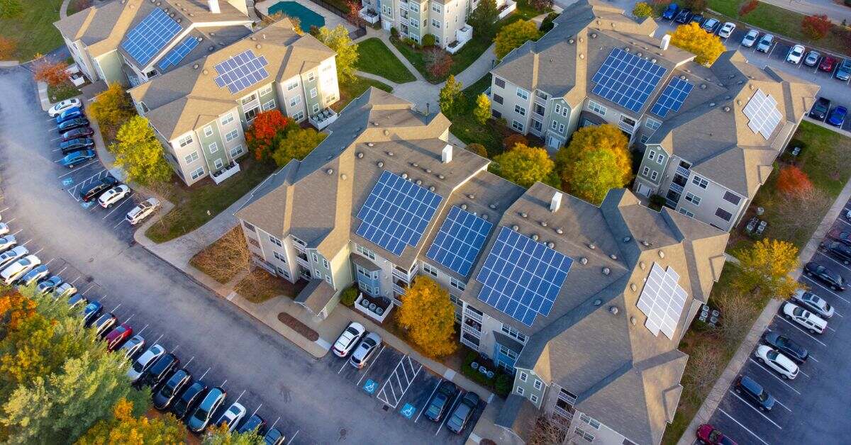 Overhead view of a multifamily community equipped with solar panels, exemplifying the integration of community solar programs to support and facilitate green energy solutions