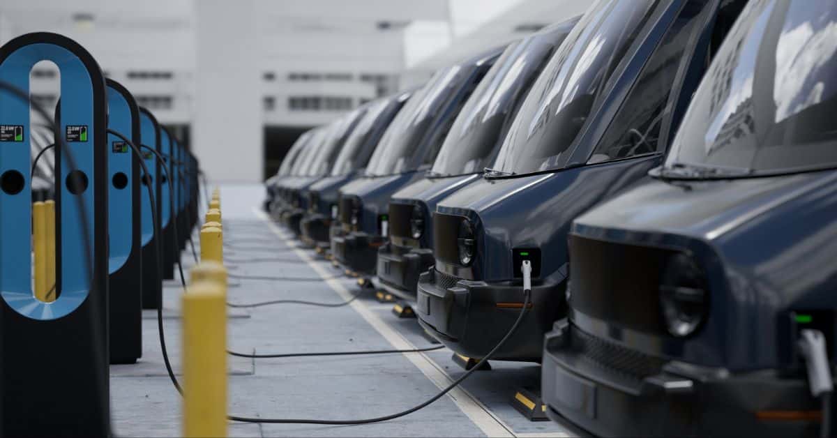 A fleet of modern electric EV delivery vans connected to chargers in a company parking garage, showcasing the innovative approach of bidirectional charging in the push towards maximizing fleet electrification