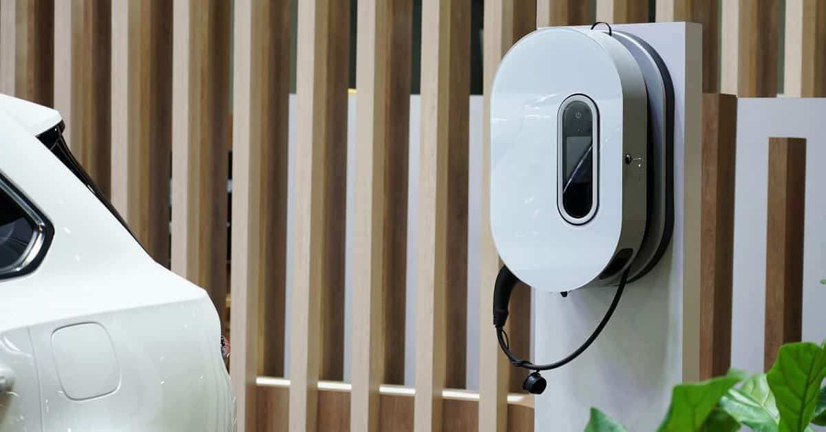 An electric vehicle connected to an EV charger at a residential property, illustrating the process of home EV charger installation and highlighting aspects that influence the overall EV installation cost